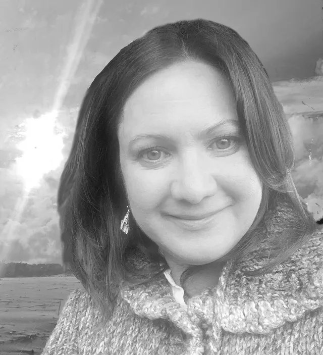 Marilyn El-Abidin smiling warmly, photographed in black and white against a bright sky